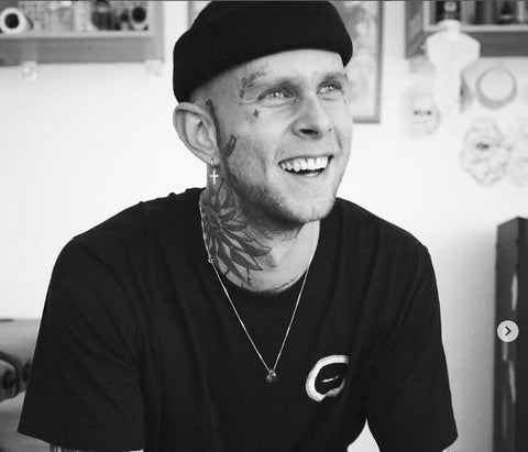 Mann mit Gesichtstätowierungen lächelnd schwarz und weiß