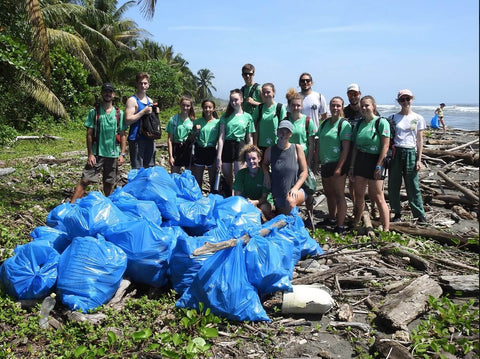 Gruppe Menschen mit vielen Müllsäcken nach Strandreinigung