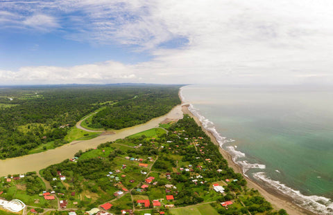 Luftaufnahme von einem Strand mit anliegendem tropischen Regenwald