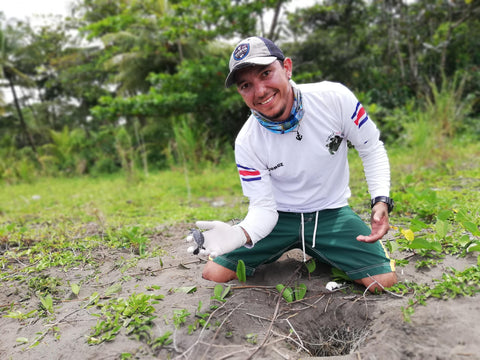Mann zeigt voller Freude eine Baby Schildkröte