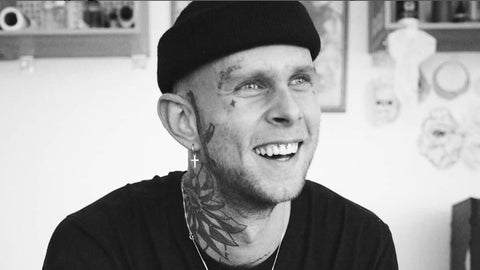 Mann mit Gesichtstattoos lacht