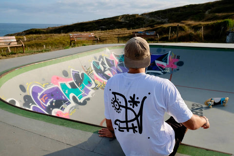 Mann sitzt am Rand einer Skatebowl