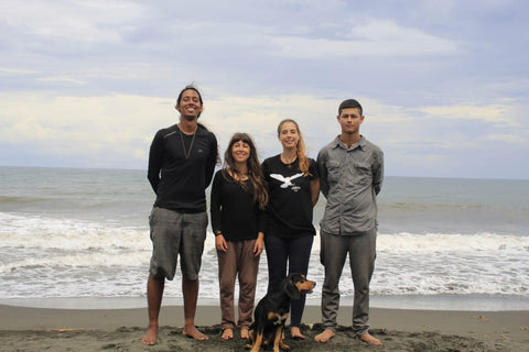 Zwei Männer und zwei Frauen am Strand mit Hund