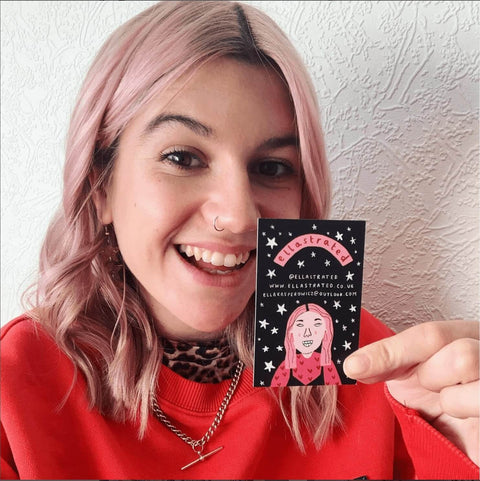 Mädchen mit rosa Haaren und Nasenpiercing zeigt lächelnd ihre Visitenkarte