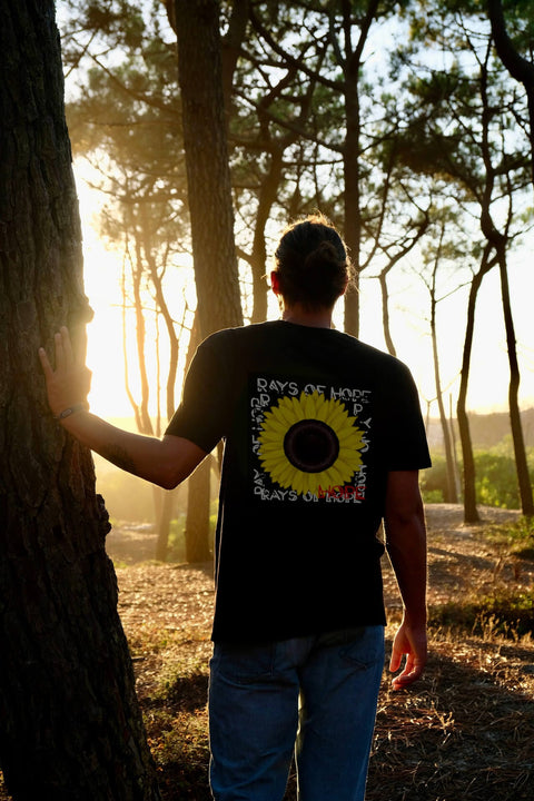 Mann steht im Wald und die Sonne geht unter